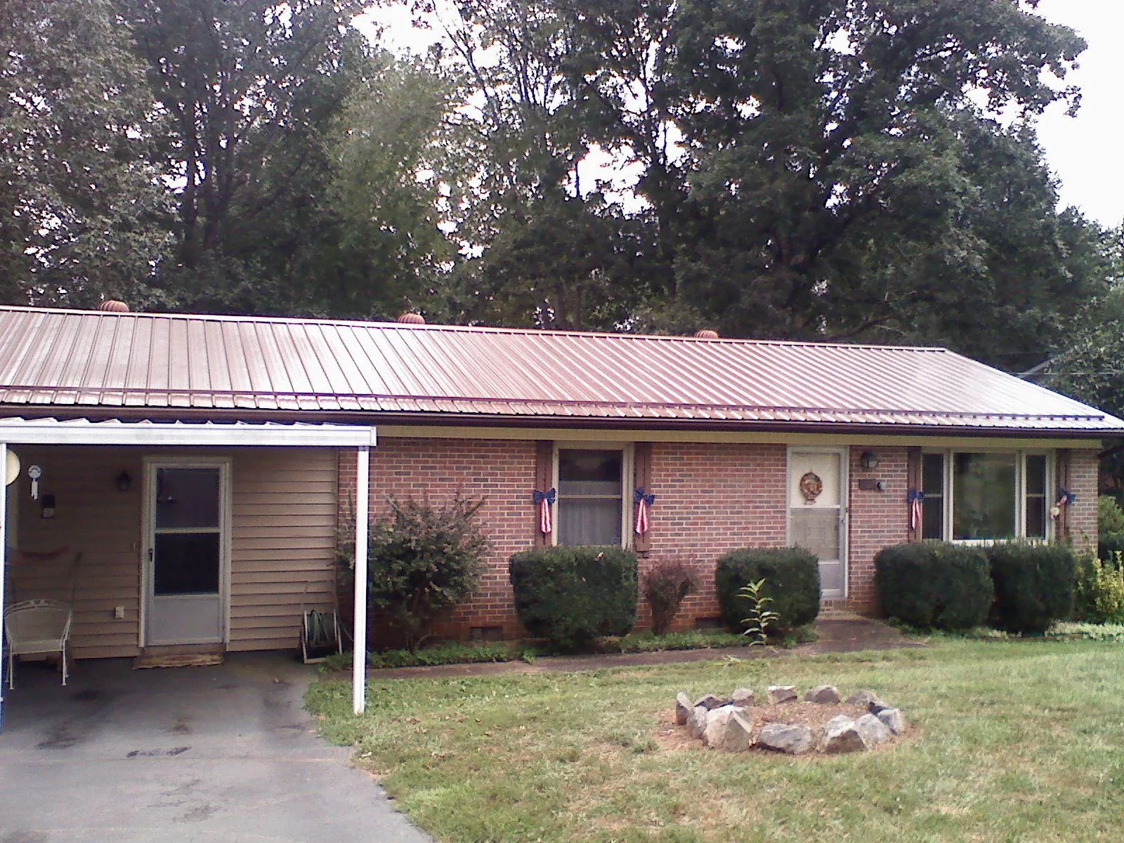 Bronze metal roof and carport on a brick ranch home — Roof Repair work by our crew in Berkshire